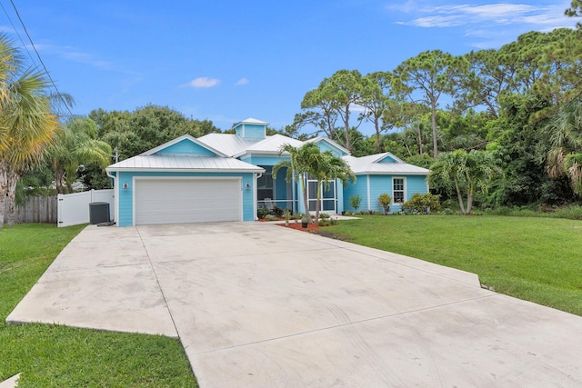 single story home featuring a front yard, a garage, and central AC unit