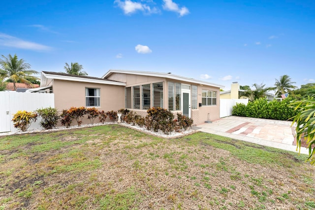 rear view of house with a patio and a yard