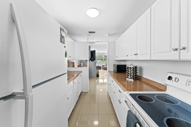 kitchen with white cabinets, white appliances, and light tile patterned floors