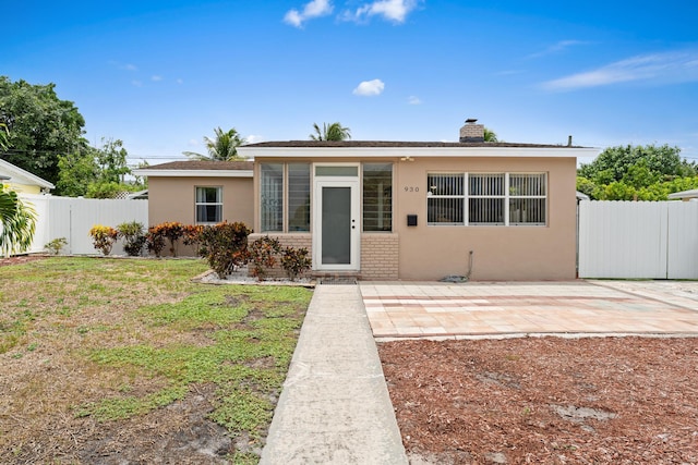 rear view of property featuring a patio area and a lawn