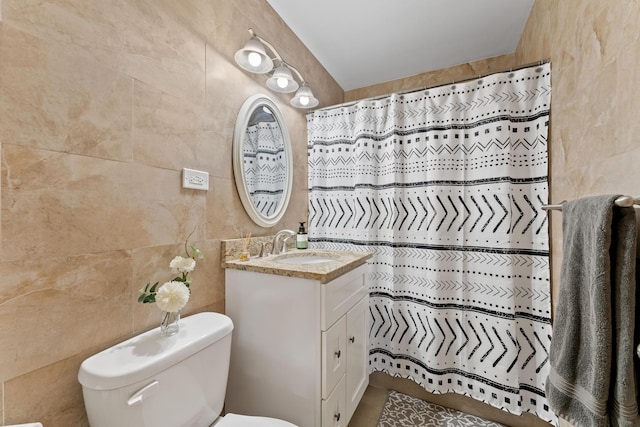 bathroom with vanity, tile walls, toilet, and tile patterned flooring