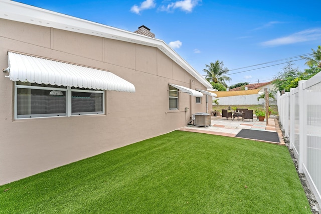 view of yard with central air condition unit and a patio area