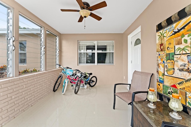 sunroom featuring ceiling fan