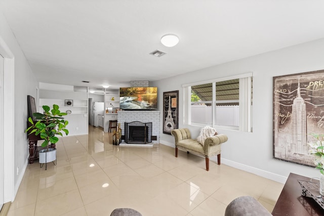 living room with a fireplace and light tile patterned floors