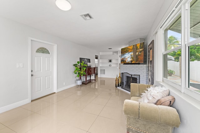 tiled living room featuring a fireplace and built in shelves