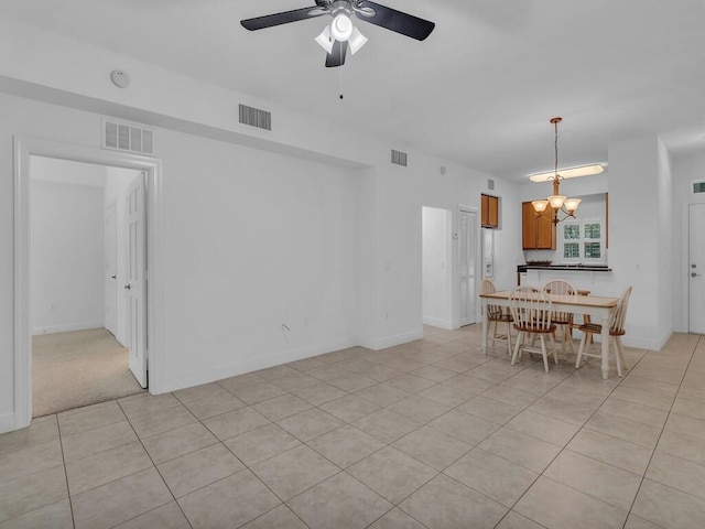 dining room featuring ceiling fan with notable chandelier and light tile patterned floors