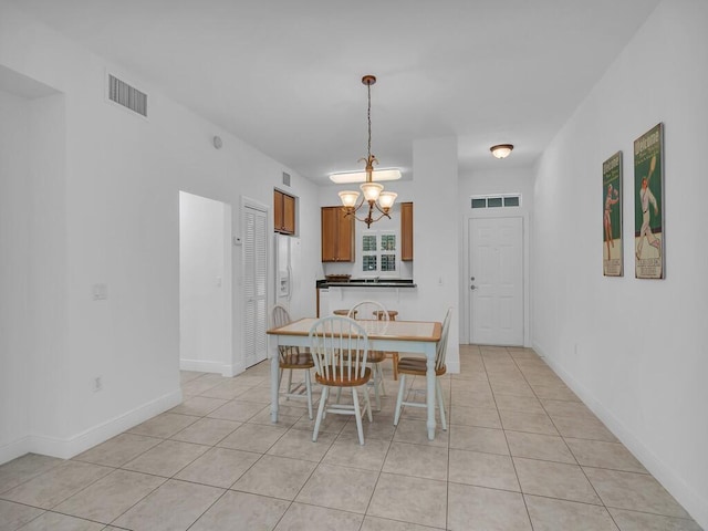 dining area with a notable chandelier and light tile patterned floors