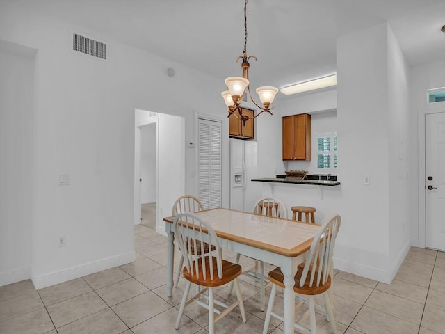 dining space featuring light tile patterned floors and an inviting chandelier