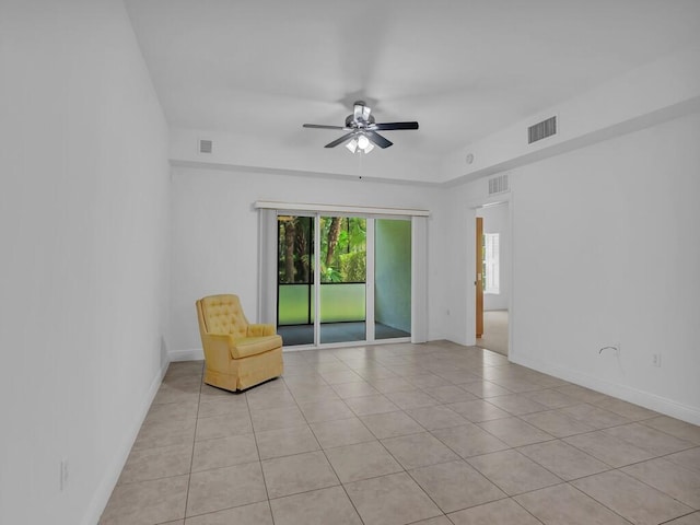 tiled spare room with ceiling fan