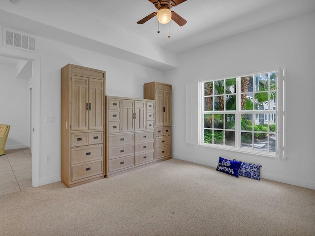 interior space with multiple windows, light carpet, and ceiling fan