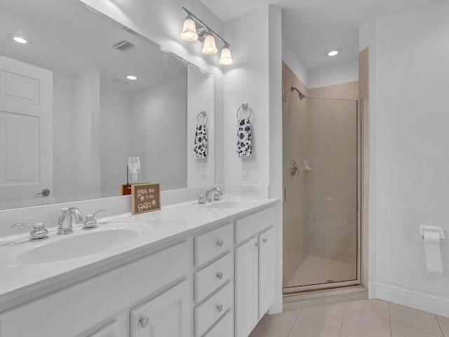 bathroom featuring double vanity, walk in shower, and tile patterned floors