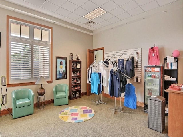 recreation room featuring a drop ceiling and carpet floors