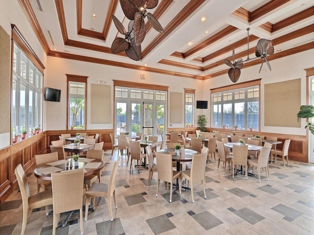 tiled dining space with a high ceiling, ceiling fan, ornamental molding, and coffered ceiling