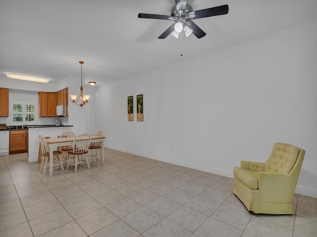 tiled dining area featuring ceiling fan with notable chandelier