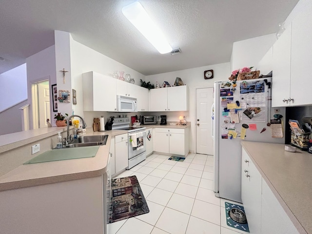 kitchen with light tile patterned flooring, white cabinetry, white appliances, a textured ceiling, and sink