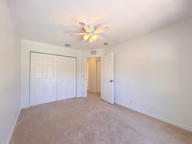 tiled bedroom featuring ceiling fan, a tray ceiling, ensuite bathroom, a walk in closet, and a closet