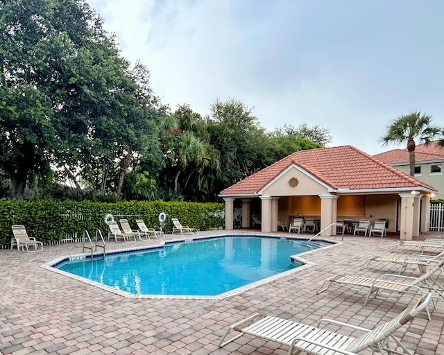 view of swimming pool with a patio and an outdoor structure