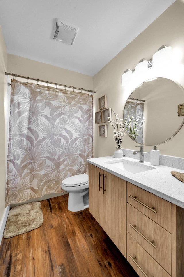 bathroom with vanity, hardwood / wood-style floors, and toilet