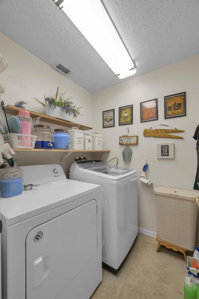 washroom featuring washing machine and dryer and a textured ceiling