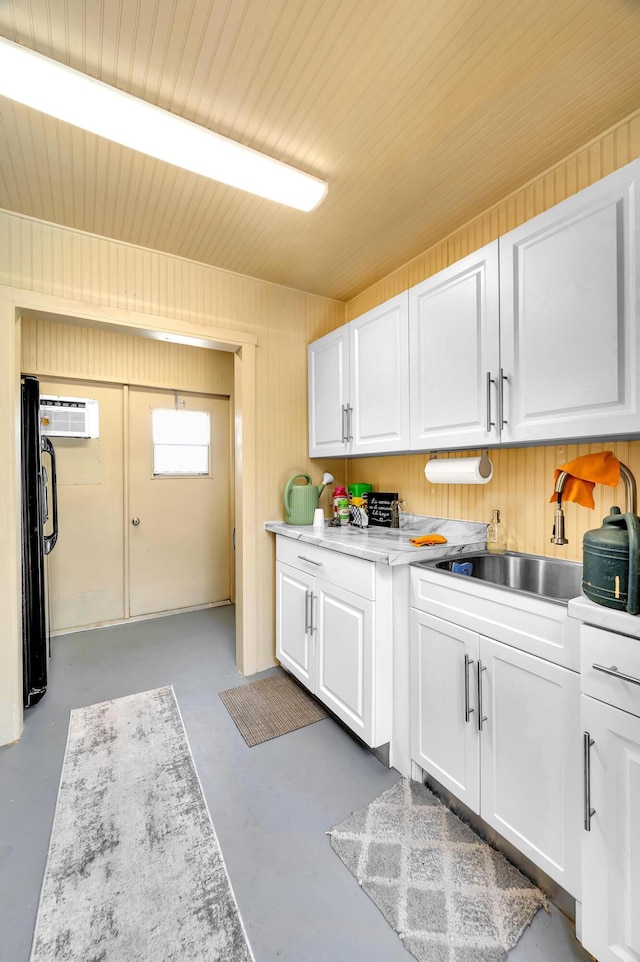 washroom with sink, a wall unit AC, and wooden walls