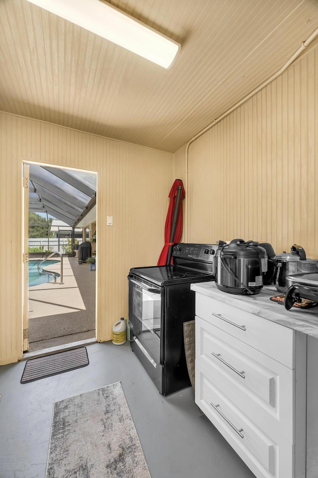 misc room featuring wooden walls and concrete flooring