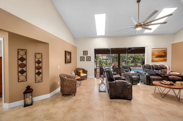 living room featuring ceiling fan, lofted ceiling with skylight, and light tile patterned floors