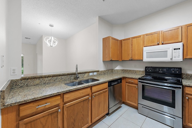 kitchen featuring sink, appliances with stainless steel finishes, kitchen peninsula, and light stone countertops