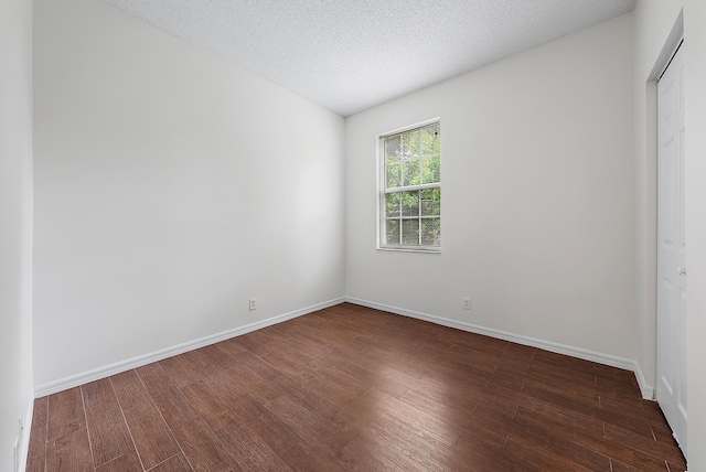 unfurnished bedroom featuring a textured ceiling, a closet, and hardwood / wood-style floors