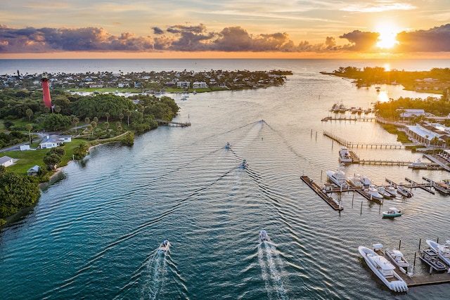 aerial view at dusk featuring a water view