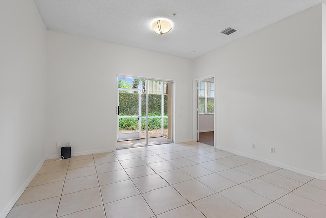 empty room featuring light tile patterned flooring and a textured ceiling