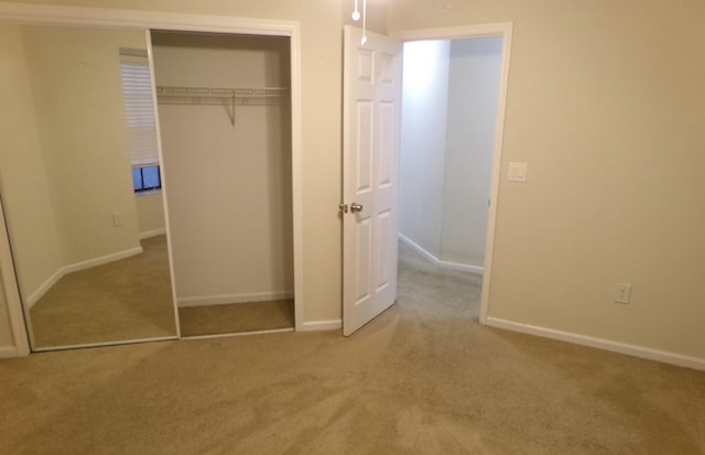 unfurnished bedroom with light carpet and a closet