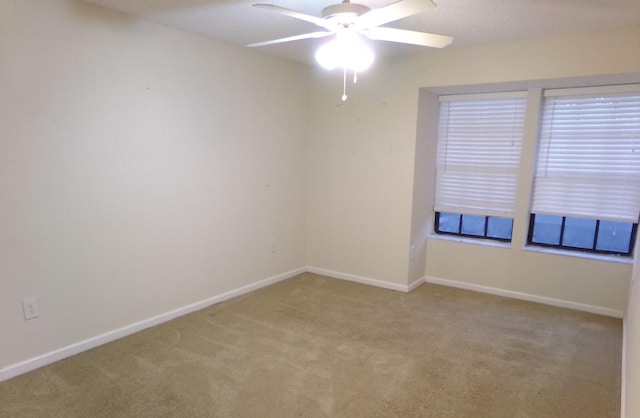 carpeted spare room with ceiling fan