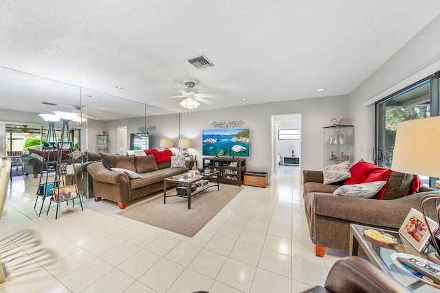 tiled living room featuring a textured ceiling and ceiling fan