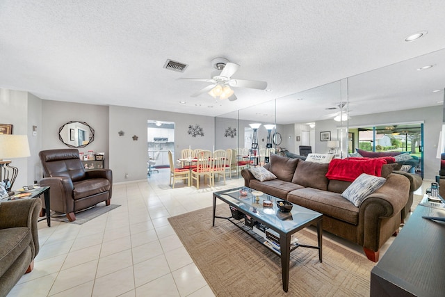 tiled living room with a textured ceiling and ceiling fan