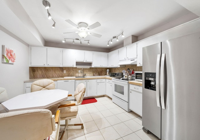 kitchen featuring backsplash, sink, light tile patterned floors, white cabinets, and white appliances