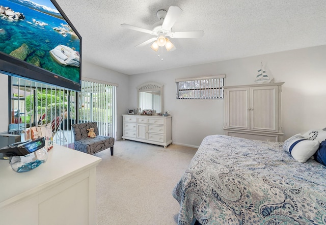 bedroom with a textured ceiling, light colored carpet, and ceiling fan