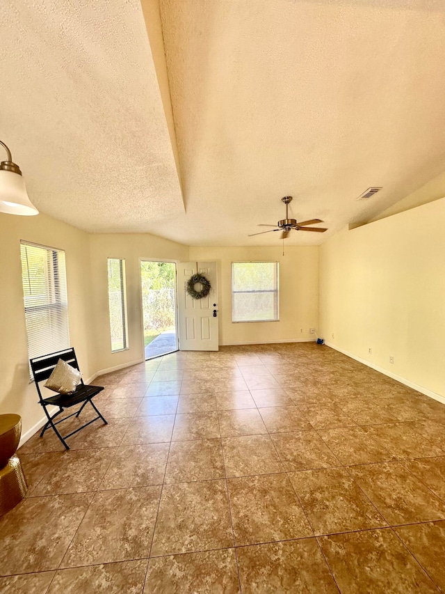 foyer entrance featuring ceiling fan, tile patterned floors, and a textured ceiling