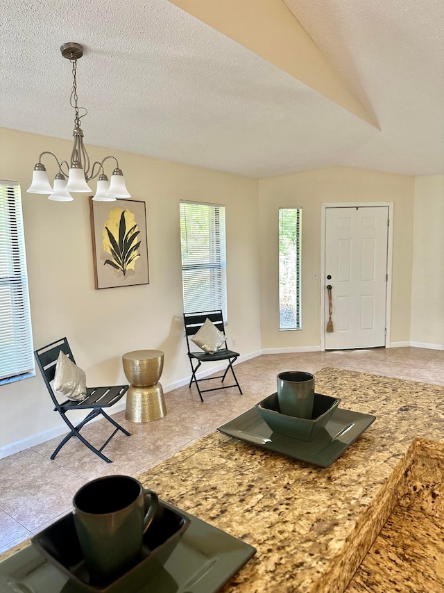 living room with a textured ceiling, vaulted ceiling, and a notable chandelier