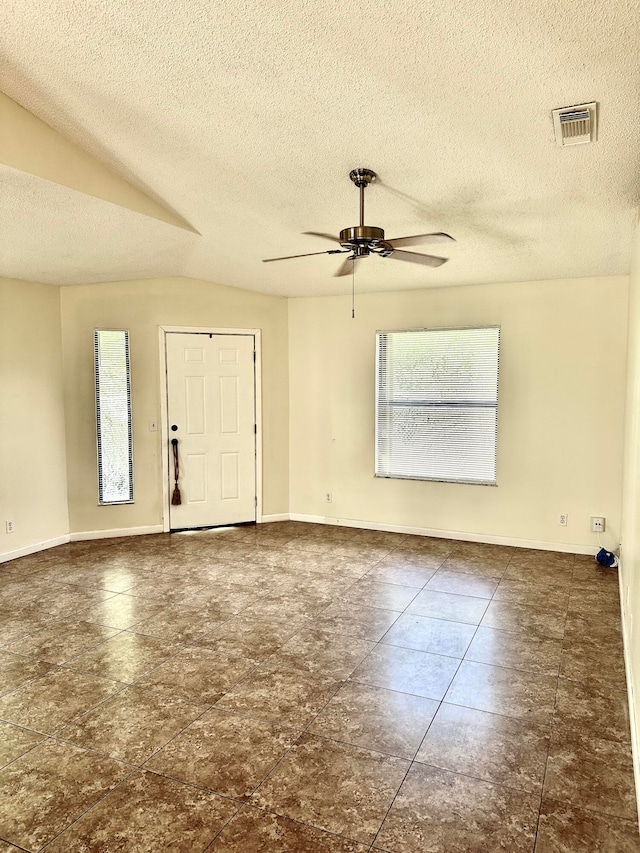 foyer featuring ceiling fan, a textured ceiling, and lofted ceiling