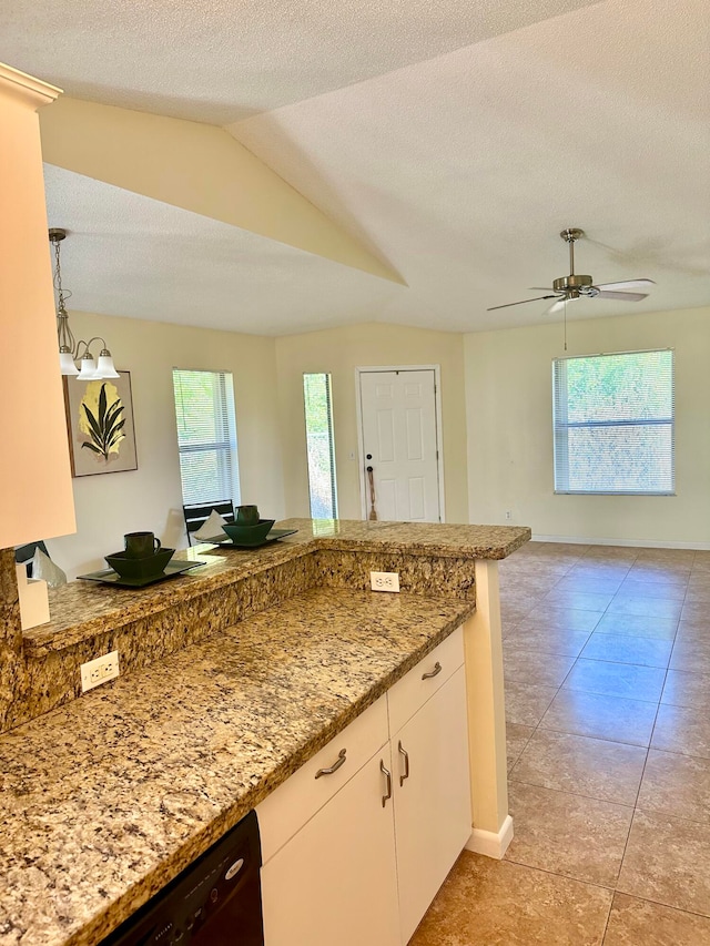 kitchen featuring a textured ceiling, pendant lighting, white cabinetry, vaulted ceiling, and light stone counters