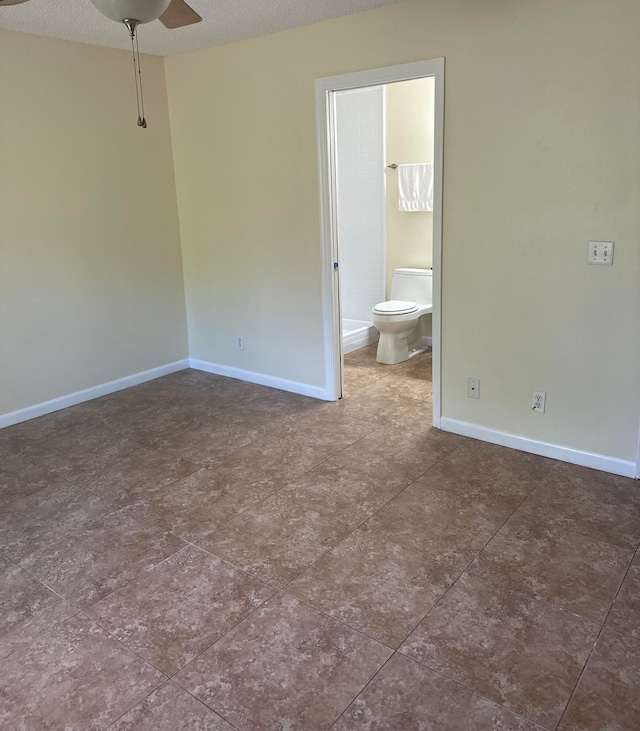 unfurnished bedroom with ceiling fan, connected bathroom, and a textured ceiling