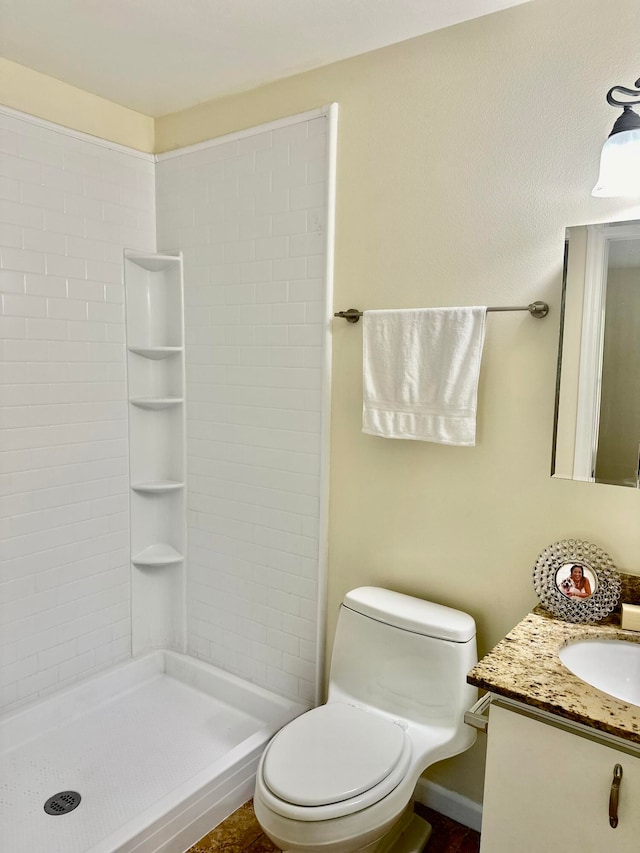 bathroom featuring toilet, walk in shower, and vanity