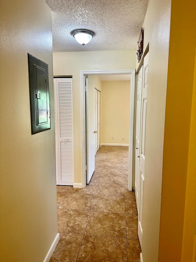 hall with electric panel and a textured ceiling