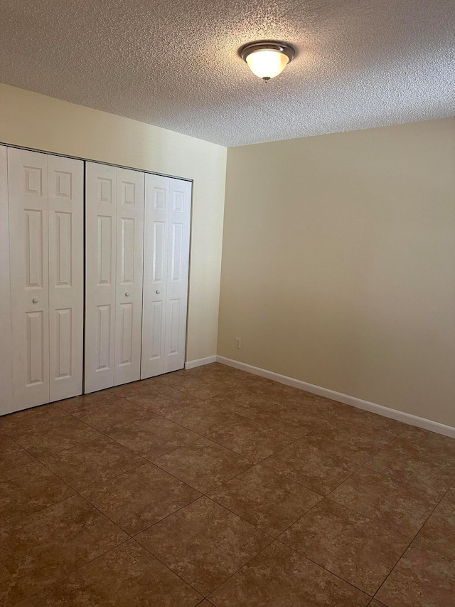 unfurnished bedroom featuring a closet and a textured ceiling