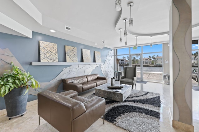 living room featuring a wall of windows, a water view, and light tile patterned floors