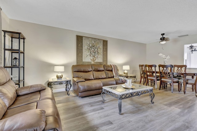 living room featuring light wood-type flooring and ceiling fan