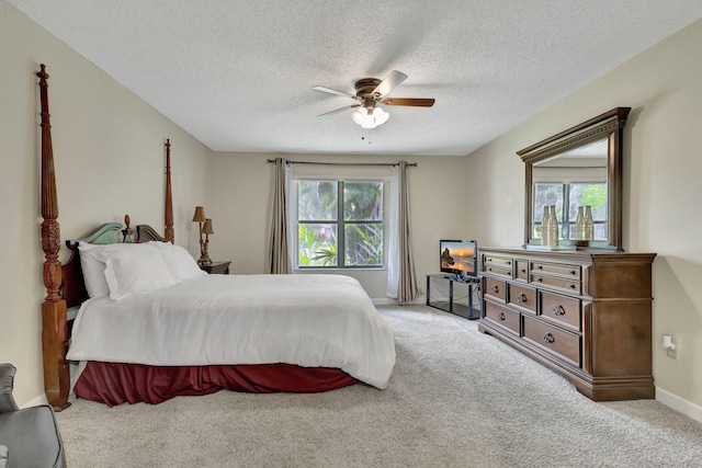 carpeted bedroom with multiple windows, a textured ceiling, and ceiling fan