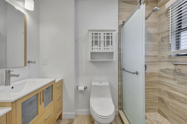 bathroom with vanity, tiled shower, wood-type flooring, and toilet