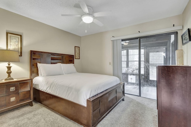 carpeted bedroom featuring access to outside, a textured ceiling, and ceiling fan