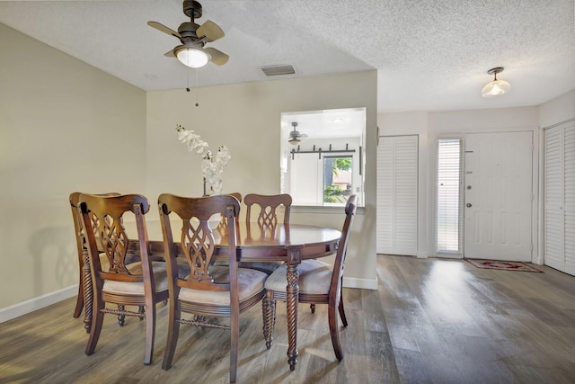 dining room featuring a textured ceiling, wood-type flooring, and ceiling fan